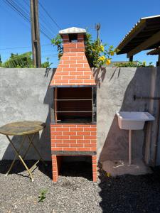 帕苏迪托雷斯Chalé hespanhol 01的一个小砖炉,配有水槽和桌子