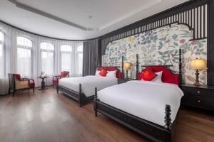 宁平Indochine Boutique Hotel Ninh Bình的酒店客房带两张床和壁画
