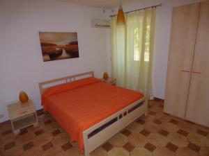 帕蒂Villa Maria的一间卧室配有一张带橙色床罩的床