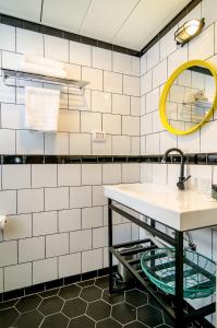 特拉维夫Dizengoff square boutique的白色瓷砖浴室设有水槽和镜子