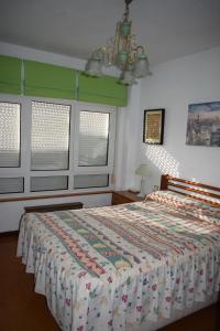 巴罗德亚尼斯Apartamento Edificio Vistamar - Playa de Barro的一间卧室配有床,床上装有被子