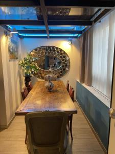 米兰Crystal Loft Luxury Milano的一间带木桌和镜子的用餐室
