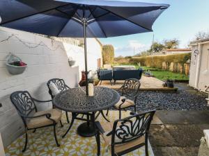 拉内利5 Pontardulais Road的庭院内桌椅和遮阳伞