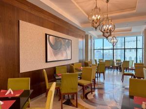 麦加Al Safwah Hotel First Tower的一间带桌椅的用餐室和一幅画