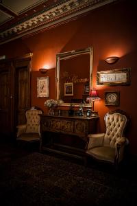 格拉斯哥阿拉莫旅馆的一间设有镜子、一张桌子和椅子的客房