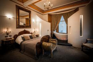 格拉斯哥阿拉莫旅馆的卧室配有1张床、浴缸和镜子
