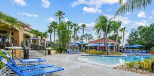 基西米201 Hideaway beach 4 beds - pool&spa的一个带蓝色躺椅和棕榈树的度假游泳池