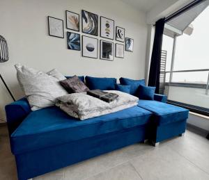 埃默里希PISO SUPERIOR - Exklusives Apartment an der Promenade mit Rheinsicht & Loggia的墙上挂着照片的房间的蓝色沙发