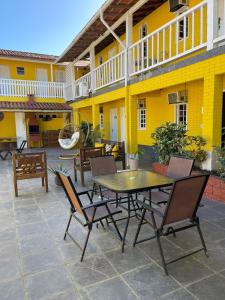 布希奥斯canto de Geriba的黄色建筑前方的带桌椅的庭院
