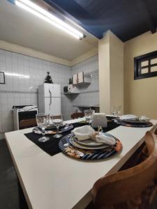 彼得罗波利斯Apartamento no bairro Quitandinha - Petrópolis RJ的厨房配有带盘子和酒杯的桌子