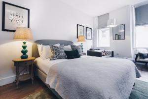 奇切斯特South Street Apartments的一间卧室配有一张床和一张带台灯的桌子