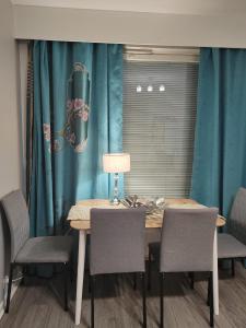 坦佩雷City Apartment的餐桌、椅子和蓝色窗帘