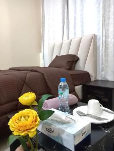 阿布扎比MBZ - Comfortable Room in Unique Flat的睡床旁的咖啡桌旁的一瓶水