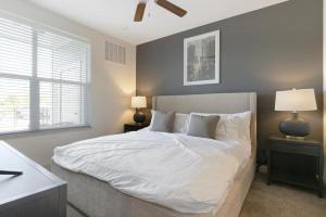 堪萨斯城Landing Modern Apartment with Amazing Amenities ID8348X93的一间卧室配有一张带白色床单和两盏灯的床。
