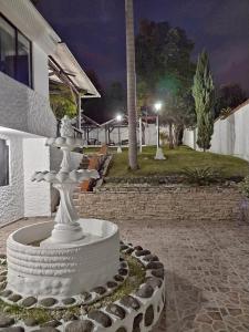 圣罗莎德卡瓦尔Casa La Riviera的夜间在建筑物前的白色喷泉