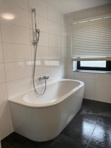阿纳姆Luxe Appartement Marc的带窗户的浴室内的白色浴缸