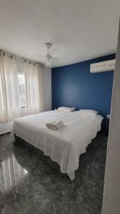 卡波布里奥Dunas 3 quartos的一间卧室配有一张白色大床和蓝色的墙壁