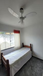 卡波布里奥Dunas 3 quartos的一间卧室配有一张床和吊扇