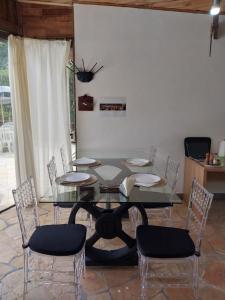PiraquaraChacara Recanto Vale do Luar的一间设有玻璃桌和椅子的用餐室
