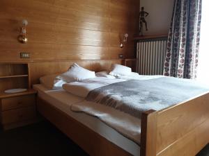 圣克里斯蒂娜加尼小屋的一间卧室配有一张木墙床