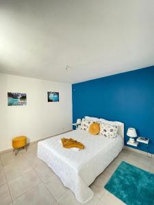 圣弗朗索瓦Résidence Subtropicale的卧室配有白色床和蓝色墙壁