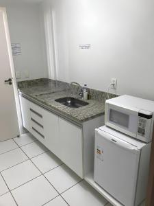 卡达斯诺瓦斯LAGOA QUENTE FLATS的厨房配有水槽和微波炉