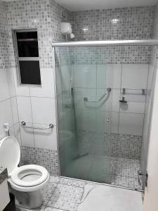 卡达斯诺瓦斯LAGOA QUENTE FLATS的浴室设有玻璃淋浴间和卫生间