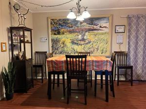ColumbusHole in the Wall Getaway USA/Mexico的用餐室配有桌椅和绘画作品