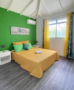 圣弗朗索瓦Résidence Subtropicale的一间卧室设有一张大床和绿色的墙壁