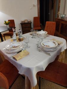 斯坎诺Bed & Breakfast Costanza4的一张带盘子和玻璃杯的白色桌子