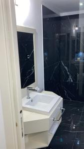 蒙泰斯库达伊奥Garden Relais Le Fontanelle的浴室设有白色水槽和镜子