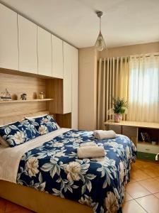 地拉那SkyView Oasis Premium Apartment的一间卧室配有一张带蓝白色毯子的床