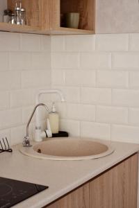 阿拉木图Уютный домик для идеального отдыха的厨房内的水槽,铺有白色的瓷砖墙