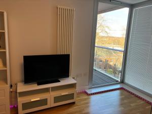 莱斯特LUXURY Leicester apartment的客厅配有平面电视和大窗户。