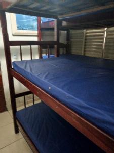 索罗卡巴Espaço com piscina的一张带蓝色床单的木制双层床