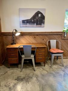 亨德森维尔Comfortable home near wineries and hiking farmhouse的办公室,配有书桌、两把椅子和一盏灯