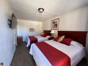威廉姆斯Arizona 9 Motor Hotel的酒店客房带两张红色和白色的床单