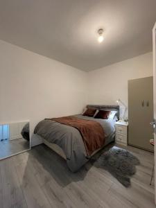 伦敦COZY ROOMS 25 min LIVERPOOL STREET的一间卧室设有一张大床,铺有木地板