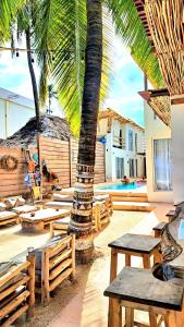 吉汶瓦Boho Boutique Villa - Beachfront Villa , Adults Only with Private Pool的一个带桌子和棕榈树的庭院和一个游泳池
