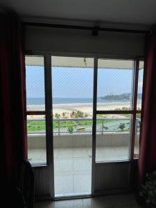 圣维森特岛Apartamento com pé na areia的通往海滩景阳台的开放式门