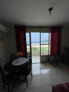 圣维森特岛Apartamento com pé na areia的一间设有桌子的海景用餐室