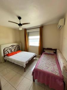圣维森特岛Apartamento com pé na areia的一间卧室设有两张床和窗户。