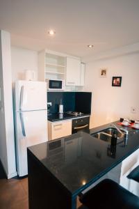 布宜诺斯艾利斯Manzanares Suites的厨房配有白色冰箱和黑色台面