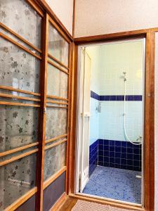 泉佐野比格汉姆之家住宿加早餐旅馆的带淋浴的浴室和玻璃门