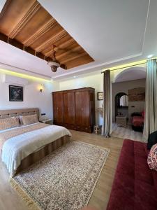 非斯费尔梅阿齐扎庄园农家乐的一间卧室配有一张大床和红色地毯。