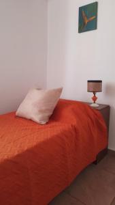 科尔多瓦Depto Viamonte - Planta Alta con Terraza y Cochera的一间卧室配有一张带枕头和灯的床