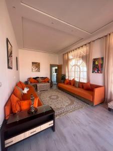 非斯费尔梅阿齐扎庄园农家乐的客厅设有2张橙色沙发和1扇窗户
