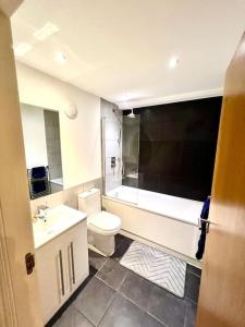 威灵堡Gem in Wellingborough的浴室配有盥洗盆、卫生间和浴缸。