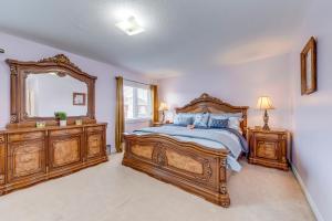 布兰普顿Avid vacation palace in Castlemore , Brampton的一间卧室配有一张大木床和镜子