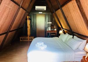 云顶高原Rustcamps Glamping Resort的一间卧室配有一张床,上面有两条毛巾